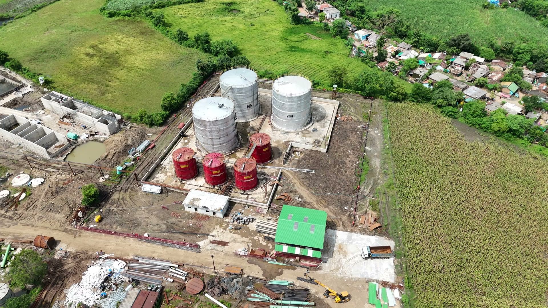 Aerial photograph of the Mahakaushal site at Bachai: the storage tanks and plant buildings, with the fields and the village around them.
