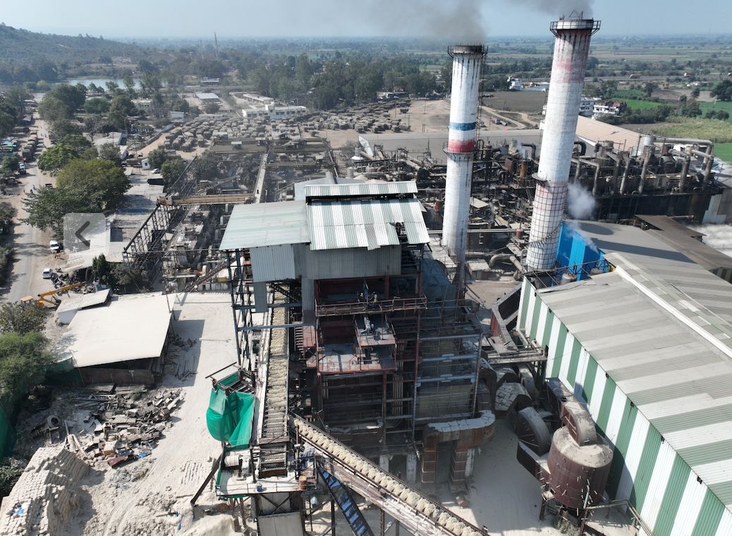 The sugar mill at Bachai, two chimneys above the plant with fields behind.